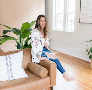 Chrystal Rose wearing a floral blazer sitting in a living room