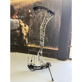 Compound bow on a white surface with a outdoor mural background