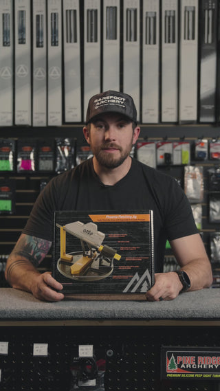 man in an archery shop behind the counter discussing the OMP fletching jig