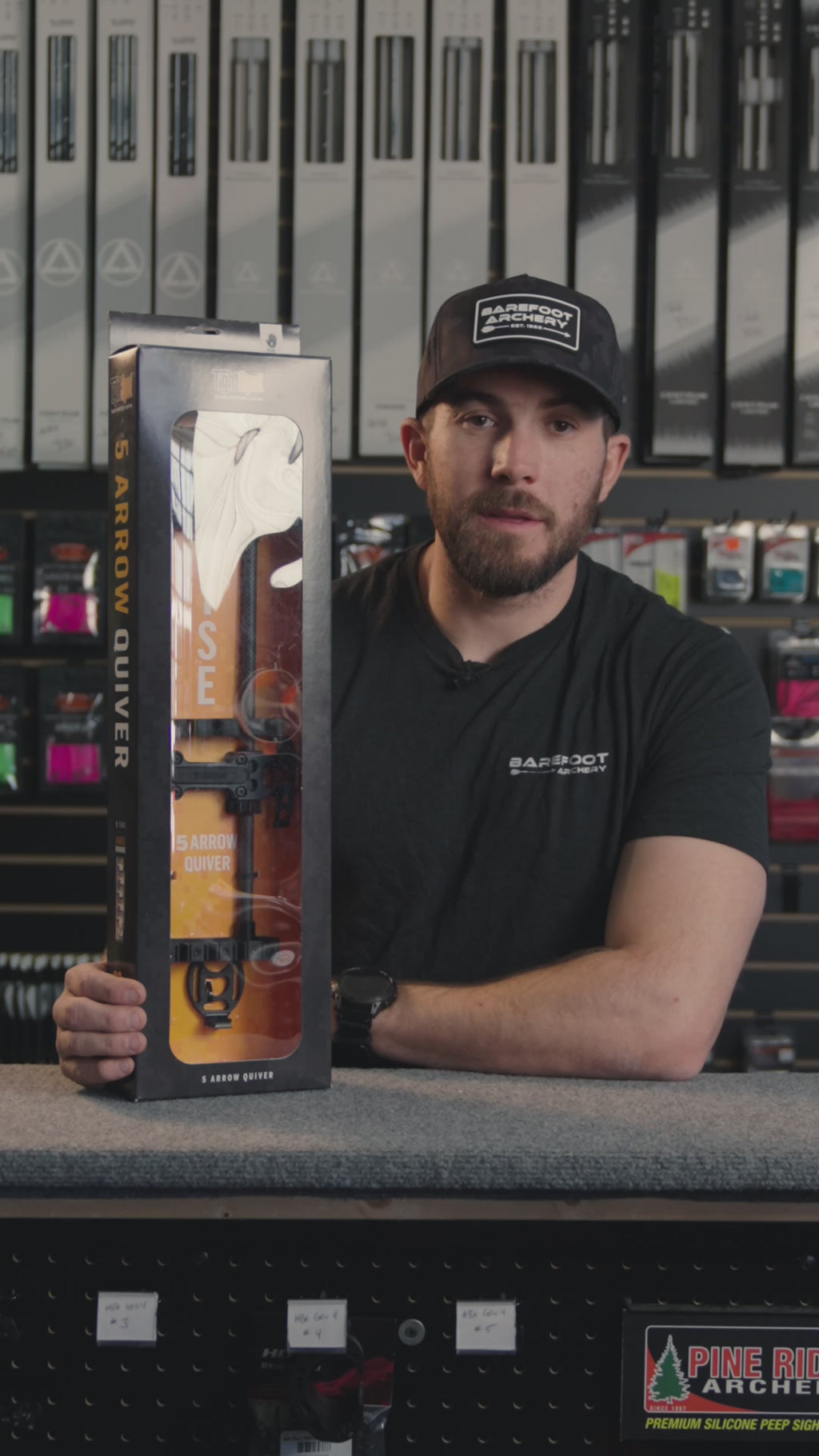 man in an archery shop behind the counter discussing the TIGHTSPOT RISE 5 ARROW QUIVER