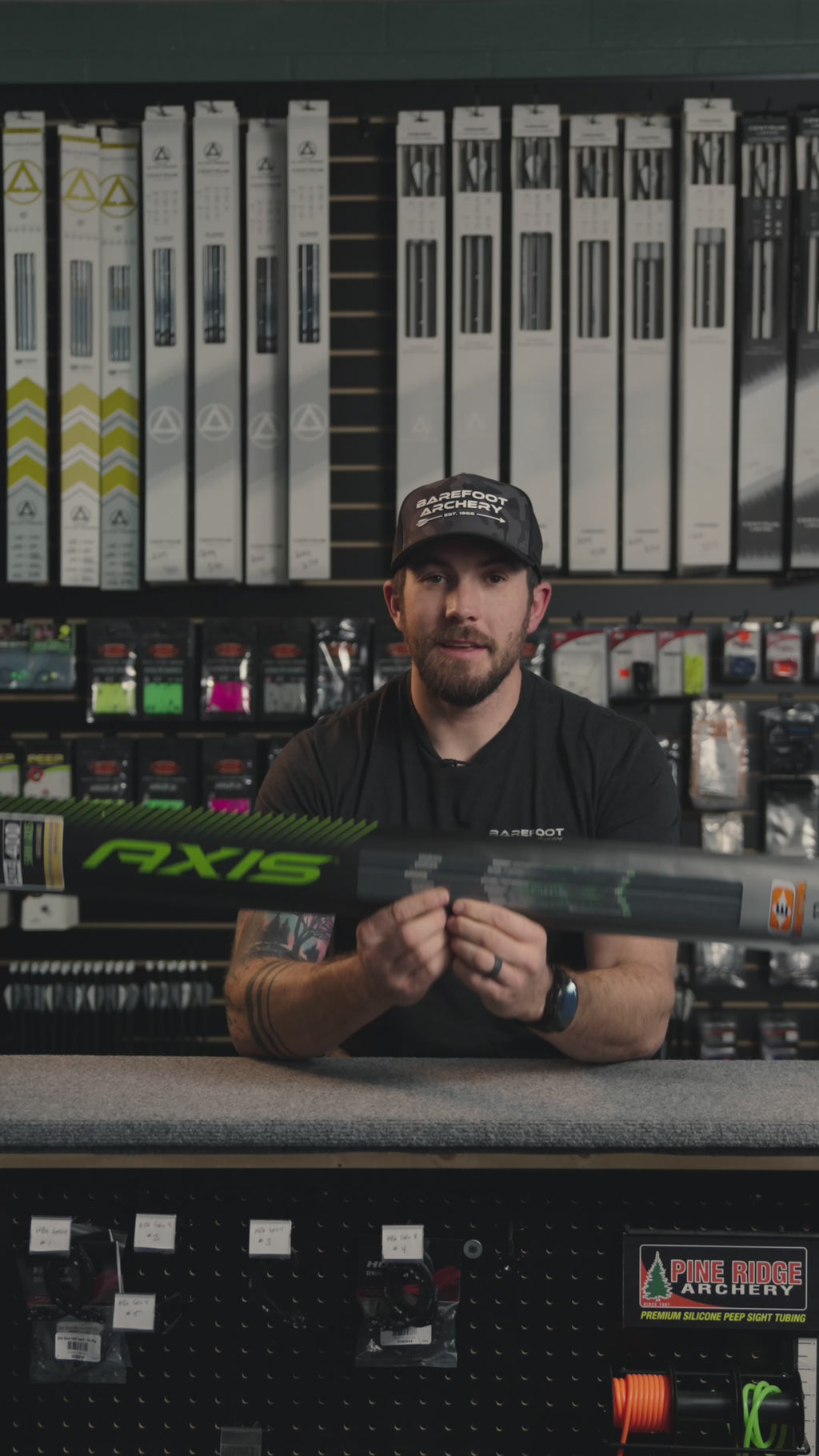 man behind the counter at an archery shop talking about easton axis arrows