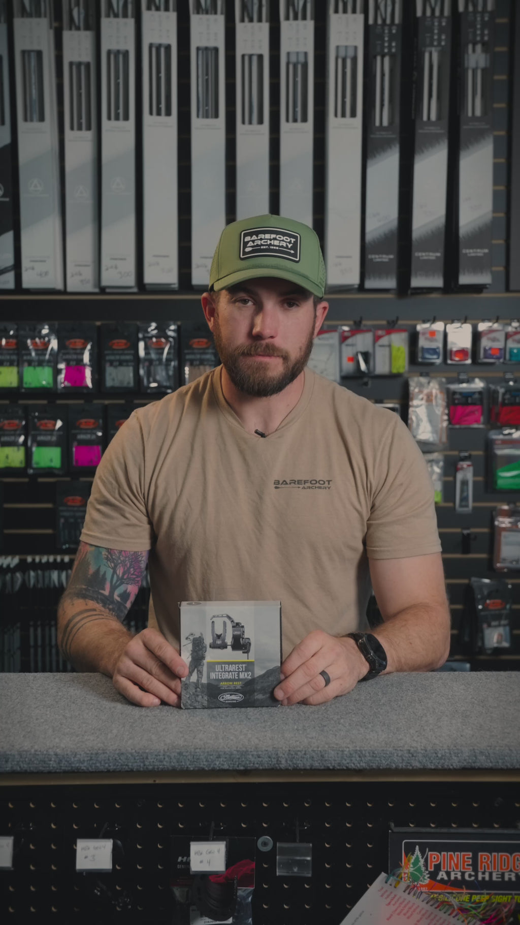 man behind the counter at an archery shop talking about  Mathews Ultra Rest MX2