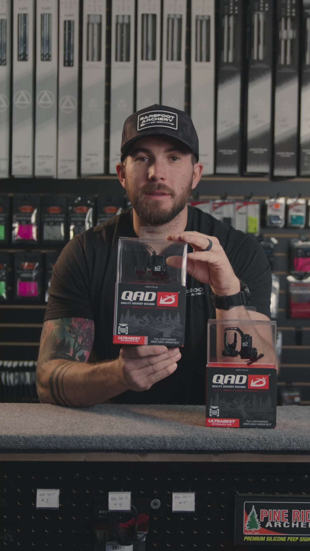 man in an archery shop behind the counter talking about the QAD ultrarest R2