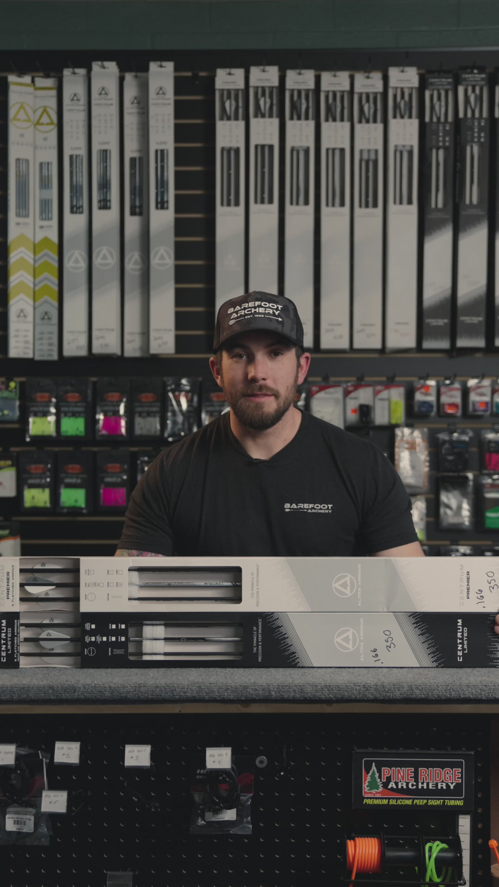 man behind the counter at an archery shop talking about Centrum Premier and Limited arrows