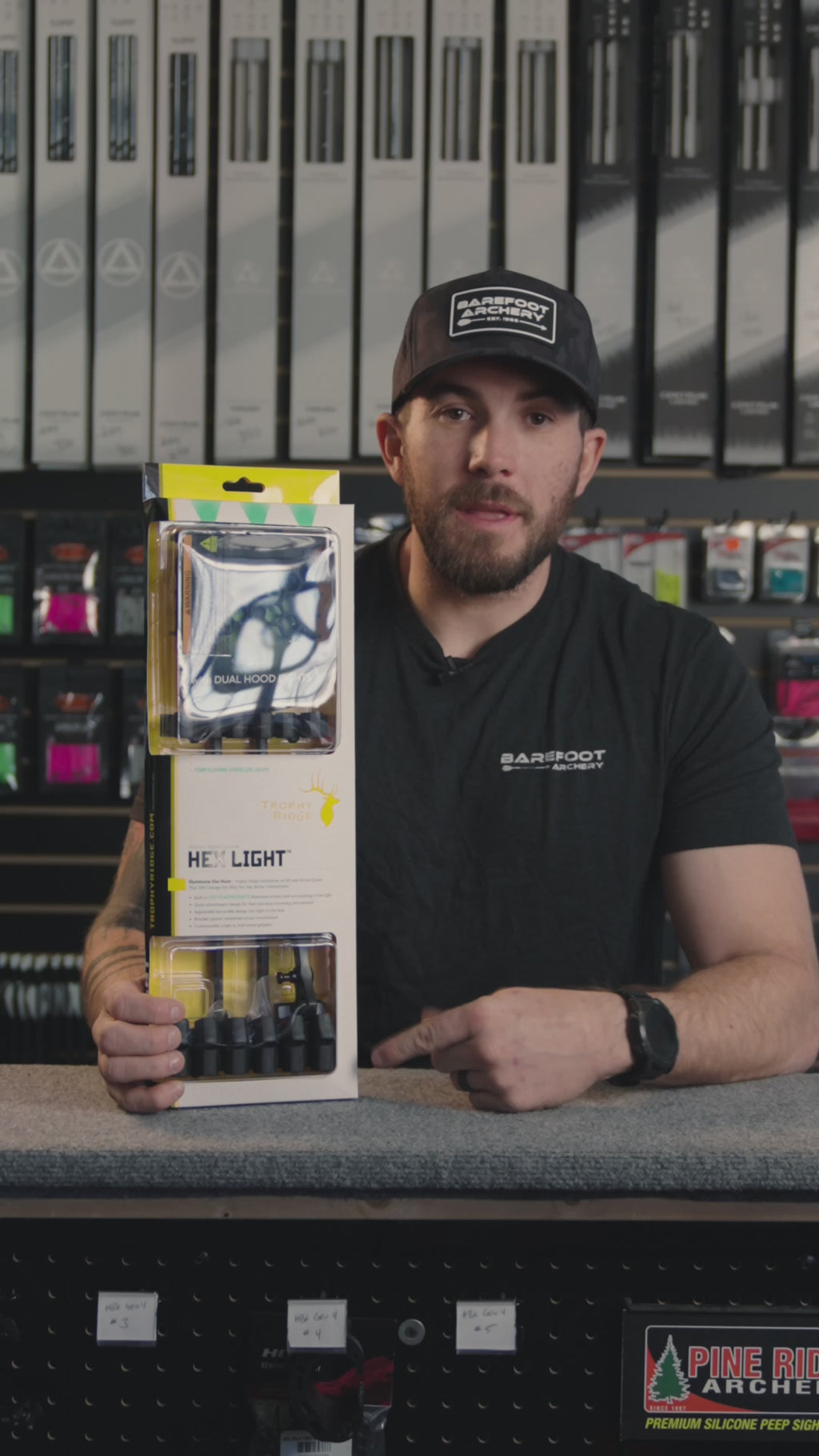 man at an archery shop behind the counter discussing the Trophy Ridge Hex Light quiver