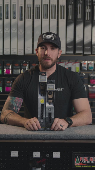 man in an archery shop behind the counter discussing the Mathews bridgelock 