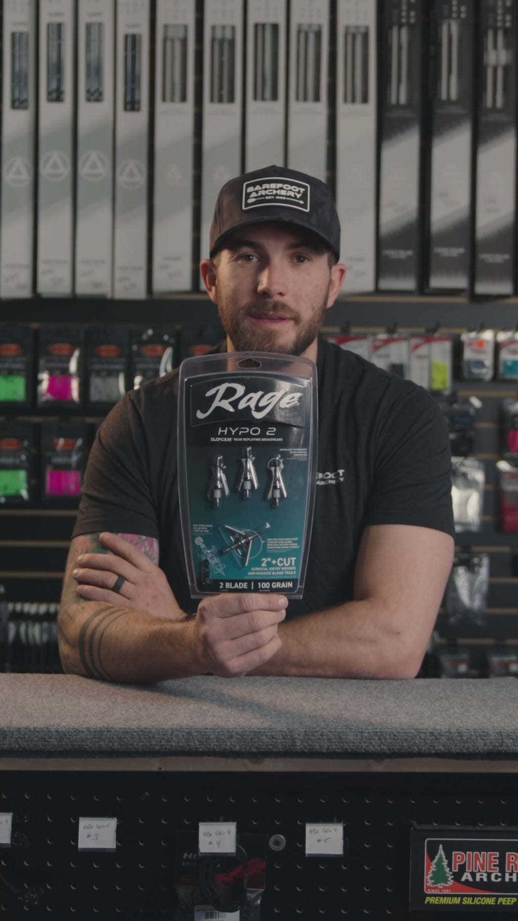 man in an archery shop behind the counter discussing Rage Hypo 2 Broadheads