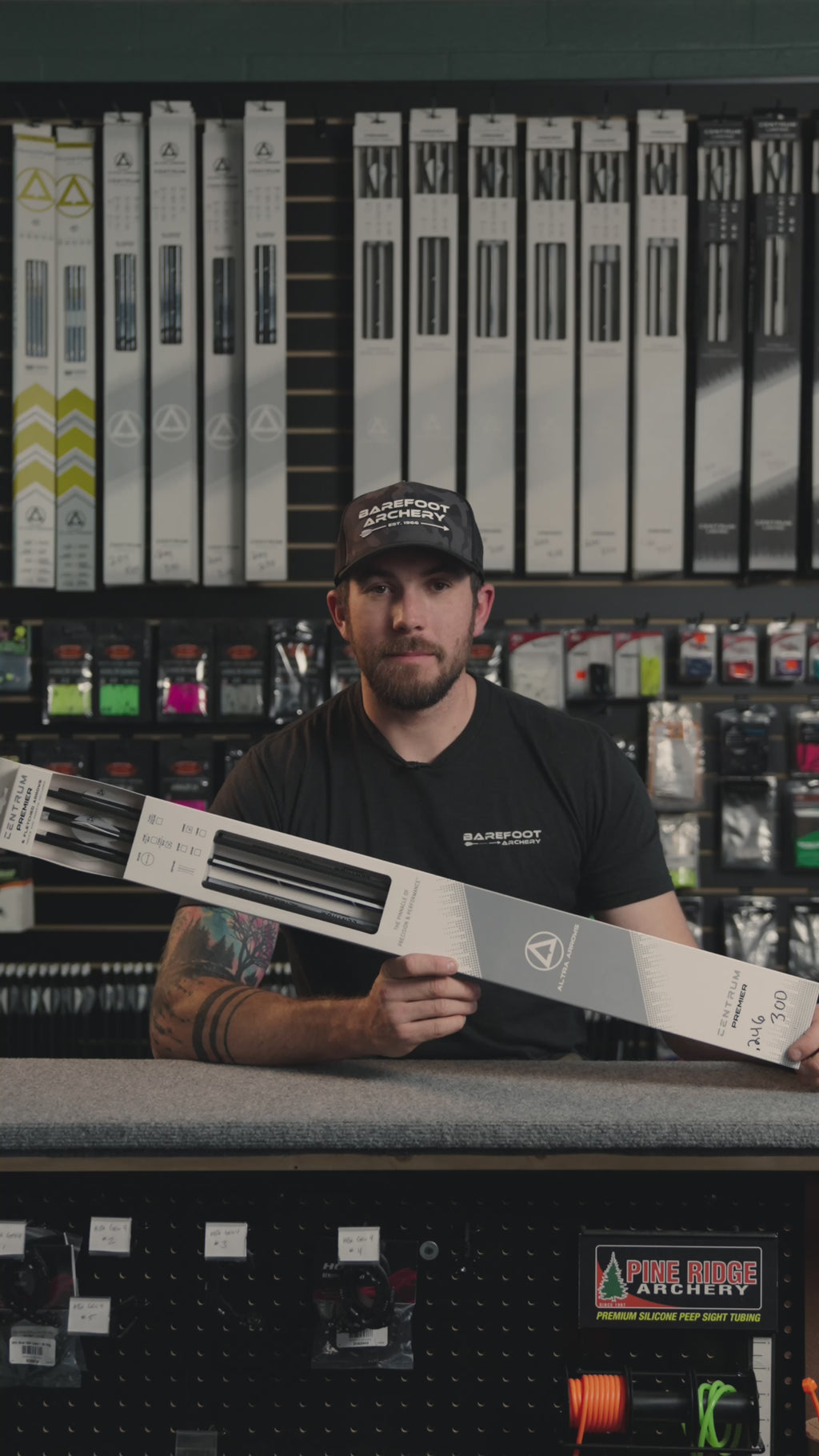 man behind the counter at an archery shop talking about centrum premier 246 arrows